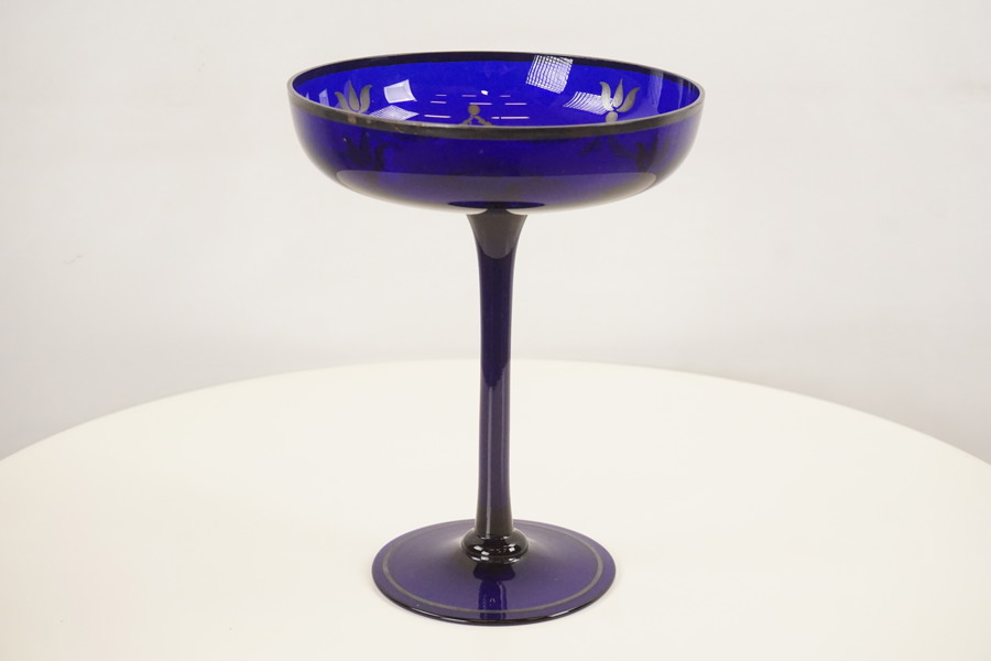 Dekorerat skål på fot i blått glas. G63